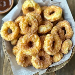 Um die perfekten Zimtzucker Churro Bites zu machen, brauchst du diese Zutaten: - 1 Tasse Allzweckmehl - 1 Esslöffel Zucker - 1/2 Teelöffel Backpulver - 1/4 Teelöffel Salz - 1/2 Tasse Wasser - 2 Esslöffel ungesalzene Butter, gewürfelt - 1/2 Teelöffel Vanilleextrakt - 1/4 Tasse Zucker (zum Wenden) - 2 Teelöffel gemahlener Zimt - Pflanzenspray Diese Zutaten sind einfach zu finden und liefern einen tollen Geschmack. Um die Zimtzucker Churro Bites zu machen, brauchst du einige Utensilien: - Ein mittlerer Kochtopf - Ein Spritzbeutel mit Sterntülle - Eine Luftfritteuse - Eine Schüssel zum Mischen - Ein Löffel zum Rühren Mit diesen Utensilien wird die Zubereitung einfach und macht Spaß. Wenn du etwas ändern möchtest, gibt es Alternativen: - Ersetze Allzweckmehl durch Vollkornmehl für mehr Ballaststoffe. - Nutze Kokosöl anstelle von Butter für einen leichten Kokosgeschmack. - Verwende Honig statt Zucker für eine gesündere Süße. Diese Alternativen geben deinen Churro Bites eine eigene Note. Zuerst mache ich den Teig. Ich nehme einen mittleren Kochtopf und gebe Wasser, Butter und einen Esslöffel Zucker hinein. Dann erhitze ich die Mischung bei mittlerer Hitze, bis sie kocht. Sobald das passiert, nehme ich den Topf vom Herd. Jetzt kommt das Mehl, Backpulver und Salz dazu. Ich rühre alles kräftig, bis der Teig glatt ist. Danach lasse ich den Teig etwa fünf Minuten abkühlen. Das ist wichtig, damit er sich gut verarbeiten lässt. Jetzt heize ich die Luftfritteuse auf 180°C vor. Diese Temperatur sorgt dafür, dass die Churro Bites außen knusprig und innen weich werden. Während die Fritteuse sich aufheizt, füge ich den Vanilleextrakt zum abgekühlten Teig hinzu. Ich rühre gut, bis alles gleichmäßig vermischt ist. Als Nächstes fülle ich den Teig in einen Spritzbeutel mit Sterntülle. Dadurch bekommen die Churro Bites ihre typische Form. Ich spritze kleine Portionen von etwa 2,5 cm direkt in den Korb der Luftfritteuse. Dabei lasse ich Platz zwischen den Stücken, da sie beim Frittieren aufgehen. Ich besprühe die Churro Bites leicht mit Pflanzenspray, damit sie schön knusprig werden. Jetzt frittieren die Churro Bites für 8 bis 10 Minuten, bis sie goldbraun und aufgeblasen sind. Während sie frittieren, mische ich in einer Schüssel den restlichen Zucker mit Zimt. Nach dem Frittieren nehme ich die Churro Bites sofort heraus und wende sie großzügig in der Zimt-Zucker-Mischung. So sind sie perfekt gewürzt und bereit zum Genießen. Um die besten Churro Bites zu machen, halte dich an diese Tipps: - Teig gut abkühlen lassen: Lass den Teig nach dem Kochen etwa 5 Minuten abkühlen. So wird er leichter zu verarbeiten. - Pflanzenspray: Sprühe die Churros leicht mit Pflanzenspray. Das hilft, sie knusprig zu machen. - Richtige Größe: Spritze kleine Portionen von etwa 2,5 cm. So bleiben sie gleichmäßig und garen gut. Hier sind einige Fehler, die du vermeiden solltest: - Zu heiß frittieren: Wenn die Luftfritteuse zu heiß ist, brennen die Churros außen an. Halte die Temperatur bei 180°C. - Zu viel Teig: Lass genug Platz im Korb. Zu viel Teig kann die Churros zusammenkleben. - Nicht genug Zimt-Zucker: Wende die Churro Bites großzügig in der Zimt-Zucker-Mischung. So bekommen sie den vollen Geschmack. Für den besten Geschmack und die beste Textur beachte Folgendes: - Frische Zutaten: Verwende frisches Mehl und frische Butter. Das verbessert den Geschmack. - Verschiedene Zimtsorten: Experimentiere mit verschiedenen Zimtsorten. Ceylon-Zimt kann eine interessante Note hinzufügen. - Dips: Serviere die Churros mit geschmolzener Schokolade oder Dulce de Leche. Das macht sie noch leckerer. {{image_4}} Eine schokoladige Version der Churro Bites ist einfach und lecker. Fügen Sie einfach Kakaopulver zum Teig hinzu. Etwa 2 Esslöffel sollten reichen. Dies gibt den Churros einen reichhaltigen Schokoladengeschmack. Nach dem Frittieren können Sie die Churros in Schokoladensauce tauchen. Das macht sie besonders unwiderstehlich! Gefüllte Churros sind ein echter Hit! Hier können Sie kreativ sein. Füllen Sie die Churros mit geschmolzener Schokolade oder Vanillepudding. Verwenden Sie einen Spritzbeutel mit einer langen Tülle, um die Füllung hineinzugeben. Diese süßen Überraschungen machen jeden Biss besonders. Sie werden sicher alle begeistern! Wenn Sie eine gesündere Option suchen, probieren Sie diese Tipps. Verwenden Sie Vollkornmehl statt Allzweckmehl. Dies erhöht den Ballaststoffgehalt. Sie können auch den Zucker reduzieren. Stattdessen können Sie Honig oder Ahornsirup verwenden. Diese Alternativen machen die Churros weniger süß, aber immer noch lecker. Um die Churro Bites frisch zu halten, lege sie in einen luftdichten Behälter. Du kannst sie auch in ein sauberes Küchentuch wickeln, um die Feuchtigkeit zu halten. Achte darauf, dass die Churros ganz abgekühlt sind, bevor du sie lagerst. So vermeidest du, dass sie matschig werden. Wenn du die Churro Bites wieder aufwärmen möchtest, benutze die Luftfritteuse. Stelle sie auf 160°C (320°F) und erwärme sie für etwa 3-5 Minuten. So werden sie wieder knusprig. Du kannst auch den Ofen verwenden, aber die Luftfritteuse ist schneller und einfacher. Die Churro Bites bleiben in einem luftdichten Behälter etwa 2-3 Tage frisch. Nach diesem Zeitraum könnten sie trocken und weniger lecker werden. Du kannst sie auch einfrieren. In einem geeigneten Behälter halten sie sich bis zu 2 Monate. Wenn du sie aufwärmst, sind sie fast wie frisch zubereitet! Die Zubereitung der Churro Bites dauert etwa 25 Minuten. Die Vorbereitungszeit beträgt 15 Minuten. Danach frittierst du sie in der Luftfritteuse für 8 bis 10 Minuten. Es ist schnell und macht Spaß! Ja, du kannst die Churro Bites auch im Ofen backen. Heize deinen Ofen auf 200°C (400°F) vor. Spritze die Teigstücke auf ein Backblech. Backe sie 12 bis 15 Minuten, bis sie goldbraun sind. Die Churros werden jedoch nicht ganz so knusprig wie aus der Luftfritteuse. Churro Bites schmecken am besten mit verschiedenen Dips. Hier sind einige Vorschläge: - Geschmolzene Schokolade - Dulce de Leche - Karamellsauce - Vanilleeis Diese Dips bringen noch mehr Geschmack zu deinen leckeren Churros! In diesem Blogbeitrag haben wir die Hauptzutaten für Zimtzucker Churro Bites besprochen. Sie lernen die nötigen Utensilien kennen und entdecken Alternativen. Wir führten Sie durch die einfache Schritt-für-Schritt-Anleitung vom Teig bis zum Frittieren. Unsere Tipps halfen Ihnen, häufige Fehler zu vermeiden und die perfekte Textur zu erreichen. Außerdem fanden Sie leckere Variationen und Lagerhinweise. Churro Bites sind vielseitig und schmackhaft. Viel Spaß beim Ausprobieren und Genießen Ihrer eigenen Kreationen!