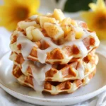 Für diese leckeren Waffel-Donuts brauchst du: - 2 Tassen Weizenmehl - 1 Esslöffel Backpulver - 1 Teelöffel Zimt - 1/2 Teelöffel Muskatnuss - 1/4 Teelöffel Salz - 1/3 Tasse Zucker - 2 große Äpfel, geschält und gewürfelt (idealerweise Granny Smith) - 1 Tasse Buttermilch - 2 große Eier - 1 Teelöffel Vanilleextrakt - 1/3 Tasse ungesalzene Butter, geschmolzen - Pflanzenöl zum Frittieren Diese Zutaten sorgen für einen saftigen und aromatischen Geschmack. Die Äpfel geben Frische, während die Gewürze einen warmen Duft verbreiten. Die Gewürze machen diesen Snack besonders. Zimt und Muskatnuss bringen Wärme und Tiefe. Sie harmonieren gut mit den süßen Äpfeln. Das Backpulver hilft, die Waffel-Donuts luftig zu machen. Salz bringt die Aromen gut zur Geltung. Mit Zucker sorgst du für die richtige Süße. Für die Glasur brauchst du: - 1 Tasse Puderzucker - 2 Esslöffel Milch - 1/2 Teelöffel Vanilleextrakt Diese Zutaten machen die Waffel-Donuts süß und glänzend. Die Glasur rundet das Geschmackserlebnis ab. Sie ist einfach und schnell zu mischen. {{ingredient_image_2}} Um den Teig für die Apfel-Küchlein Waffel-Donuts vorzubereiten, mische zuerst die trockenen Zutaten. Nimm eine große Rührschüssel. Gib 2 Tassen Weizenmehl, 1 Esslöffel Backpulver, 1 Teelöffel Zimt, 1/2 Teelöffel Muskatnuss, 1/4 Teelöffel Salz und 1/3 Tasse Zucker hinein. Vermenge alles gut. In einer anderen Schüssel verquirlst du die feuchten Zutaten. Nimm 1 Tasse Buttermilch, 2 große Eier, 1 Teelöffel Vanilleextrakt und 1/3 Tasse geschmolzene Butter. Rühre alles, bis die Mischung glatt ist. Füge die feuchten Zutaten langsam zu den trockenen hinzu. Mische vorsichtig, bis der Teig gleichmäßig ist. Hebe schließlich die 2 gewürfelten Äpfel unter. Heize dein Waffeleisen gemäß den Anweisungen vor. Fette es leicht mit Kochspray oder etwas Öl ein. Nimm etwa 1/4 Tasse Teig und gib ihn in die Mitte des Waffeleisens. Achte darauf, nicht zu viel Teig zu verwenden. Schließe den Deckel und backe die Waffeln für 3-4 Minuten. Sie sollten goldbraun und knusprig sein. Nimm die Waffeln vorsichtig heraus und lasse sie auf einem Drahtgitter abkühlen. Erhitze in einem tiefen Topf Pflanzenöl auf 350°F (175°C). Lass die abgekühlten Waffel-Donuts vorsichtig ins heiße Öl gleiten. Frittiere sie für etwa 30 Sekunden auf jeder Seite. Sie sollten goldbraun und knusprig sein. Nimm die Donuts aus dem Öl und lasse sie auf Küchenpapier abtropfen. Tauche sie in die vorbereitete Glasur, während sie noch warm sind. Lass die Glasur abtropfen und lege die glasierten Donuts wieder auf das Drahtgitter. Um die perfekte Konsistenz zu erreichen, mischst du die trockenen Zutaten zuerst gut. Das sind Mehl, Zucker, Backpulver und Gewürze. Mische sie in einer großen Schüssel. Dann kommen die feuchten Zutaten. Verquirle Eier, Buttermilch und geschmolzene Butter in einer separaten Schüssel. Gieße die Flüssigkeit langsam in die trockenen Zutaten. Rühre nur so lange, bis alles gleichmäßig vermischt ist. Klumpen sind okay, aber zu viel Rühren macht den Teig zäh. Bevor du den Teig ins Waffeleisen gibst, heize es gut vor. Dies sorgt dafür, dass die Waffeln gleichmäßig garen. Fette das Waffeleisen leicht ein. Verwende Kochspray oder ein wenig Öl. Achte darauf, nicht zu viel Teig einzufüllen. Eine Portion von etwa 1/4 Tasse reicht. Schließe den Deckel und lasse die Waffeln 3-4 Minuten backen. Lass die Waffeln kurz auf einem Drahtgitter abkühlen. So bleiben sie knusprig. Beim Frittieren musst du vorsichtig sein. Erhitze das Öl auf 350°F (175°C). Teste die Temperatur, indem du einen kleinen Teigstück hineingibst. Wenn es blubbert, ist das Öl bereit. Gleite die Waffel-Donuts vorsichtig ins Öl. Frittiere sie 30 Sekunden auf jeder Seite. Achte darauf, sie nicht zu lange zu lassen, sonst werden sie zu dunkel. Lasse die frittierten Donuts auf Küchenpapier abtropfen. So entfernst du überschüssiges Öl und hältst sie knusprig. Pro Tipps Äpfel auswählen: Verwenden Sie Granny Smith Äpfel für die beste Kombination aus Süße und Säure. Teig nicht übermixen: Mischen Sie die Zutaten nur, bis sie gerade verbunden sind, um zähe Waffeln zu vermeiden. Öltemperatur prüfen: Verwenden Sie ein Küchenthermometer, um sicherzustellen, dass das Öl die richtige Temperatur hat, bevor Sie frittieren. Glasur anpassen: Fügen Sie mehr Milch hinzu, um die Glasur dünnflüssiger zu machen, oder mehr Puderzucker, um sie dicker zu machen. {{image_4}} Sie können verschiedene Apfelsorten für die Waffel-Donuts nutzen. Granny Smith ist sauer und knusprig. Sie gibt einen tollen Geschmack. Aber auch andere Äpfel wie Braeburn oder Honeycrisp sind gut. Diese Äpfel sind süßer und sorgen für einen anderen Geschmack. Experimentieren Sie mit verschiedenen Sorten, um Ihre perfekte Mischung zu finden. Für eine glutenfreie Option verwenden Sie einfach glutenfreies Mehl. Es gibt viele gute Sorten. Sie können auch eine Mischung aus Mandelmehl und Reis- oder Hafermehl nutzen. Achten Sie darauf, dass alle anderen Zutaten ebenfalls glutenfrei sind. So können alle genießen, auch die mit Glutenunverträglichkeit. Verleihen Sie Ihren Waffel-Donuts zusätzlichen Geschmack! Fügen Sie gehackte Nüsse wie Walnüsse oder Pekannüsse hinzu. Diese geben einen schönen Crunch. Schokoladenstückchen sind eine weitere tolle Idee. Sie schmelzen beim Backen und sorgen für ein süßes, schokoladiges Erlebnis. Sie können auch Zimt oder Muskatnuss für mehr Aroma verwenden. Seien Sie kreativ! Um die Frische Ihrer Apfel-Küchlein Waffel-Donuts zu bewahren, lagern Sie sie in einem luftdichten Behälter. Das schützt sie vor Feuchtigkeit und hält sie knusprig. Stellen Sie sicher, dass die Donuts vollständig abgekühlt sind, bevor Sie sie einlagern. So bleibt der Geschmack erhalten. Lagern Sie sie bei Raumtemperatur und genießen Sie sie innerhalb von 2-3 Tagen. Wenn Sie die Waffel-Donuts länger aufbewahren möchten, können Sie sie einfrieren. Lassen Sie sie zuerst abkühlen und wickeln Sie sie dann in Frischhaltefolie. Legen Sie die eingewickelten Donuts in einen Gefrierbeutel und entfernen Sie so viel Luft wie möglich. Sie können sie bis zu 2 Monate im Gefrierfach aufbewahren. Zum Auftauen legen Sie die Donuts einfach bei Raumtemperatur für etwa 1 Stunde. Um die Waffel-Donuts wieder aufzuwärmen, können Sie den Backofen oder die Mikrowelle verwenden. Für den Ofen heizen Sie ihn auf 180°C vor. Legen Sie die Donuts auf ein Backblech und backen Sie sie für etwa 5-10 Minuten. Sie werden wieder knusprig und warm. Wenn Sie die Mikrowelle nutzen, erwärmen Sie die Donuts für 15-20 Sekunden. Dies ist schneller, kann jedoch die Knusprigkeit beeinträchtigen. Du kannst die Waffel-Donuts bis zu drei Tage aufbewahren. Lege sie in einen luftdichten Behälter. So bleiben sie frisch und lecker. Wenn du sie länger aufbewahren möchtest, friere sie ein. Das geht einfach und schnell. Achte darauf, sie gut zu verpacken. So vermeidest du Gefrierbrand. Ja, die Glasur lässt sich leicht anpassen. Du kannst zum Beispiel Schokoladenglasur statt Puderzucker verwenden. Füge einfach geschmolzene Schokolade hinzu. Für einen fruchtigen Touch, versuche Fruchtsirup. Du kannst auch Nüsse oder Kokosraspel in die Glasur einarbeiten. Sei kreativ und finde deinen eigenen Geschmack! Diese Waffel-Donuts sind eher ein Genuss als ein gesundes Snack. Sie enthalten Zucker und Butter. Aber die Äpfel bringen Vitamine und Ballaststoffe. Du kannst die Zuckermenge reduzieren, um sie etwas gesünder zu machen. Nutze auch Vollkornmehl für mehr Nährstoffe. So hast du einen leckeren, aber etwas gesünderen Donut! Die Zutaten und Schritte für Apfel-Küchlein Waffel-Donuts sind einfach. Wir haben die Hauptzutaten, Gewürze und die Glasur behandelt. Schritt für Schritt konnte jeder leicht folgen. Tipps und Tricks helfen, die besten Ergebnisse zu erzielen. Variationen bieten viele Möglichkeiten zur Anpassung. Und gutes Lagern hilft, die Leckereien frisch zu halten. Letztendlich sind diese Waffel-Donuts ein Genuss, den du teilen kannst. Probier sie unbedingt aus und entwickle deine eigenen Rezepte!