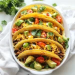 Für köstliche Käsegefüllte Ofentacos brauchen Sie folgende Hauptzutaten: - 12 kleine Tortillas aus Mais oder Weizen - 450 g Hackfleisch (Rind oder Putenfleisch) - 1 kleine Zwiebel, fein gehackt - 2 Knoblauchzehen, gehackt - 1 Päckchen Taco-Gewürzmischung - 240 ml schwarze Bohnen aus der Dose, abgetropft und abgespült - 240 ml Maiskörner (frisch oder gefroren) - 200 g geriebener Cheddar-Käse Diese Zutaten bilden die Basis für den tollen Geschmack. Die Tortillas sind wichtig, um die Füllung zu halten. Das Hackfleisch bringt die Proteine, und die Bohnen fügen eine gute Textur hinzu. Zusätzlich brauchen Sie einige Gewürze und Zutaten, um den Tacos das gewisse Etwas zu geben: - 240 ml gewürfelte Tomaten - 240 ml gehackter Kopfsalat - 120 ml Sour Cream - 1 Avocado, gewürfelt - Frischer Koriander zur Garnitur - Olivenöl zum Braten Die Taco-Gewürzmischung sorgt für den typischen Geschmack. Tomaten und Salat bringen Frische und Farbe. Sour Cream und Avocado machen die Tacos cremig und lecker. Ein paar frische Beilagen können Ihre Tacos noch besser machen. Hier sind einige Vorschläge: - Limettenviertel für zusätzliche Frische - Jalapeños für einen scharfen Kick - Weitere frische Kräuter wie Petersilie oder Schnittlauch Diese Beilagen bringen noch mehr Geschmack und Vielfalt auf den Tisch. Sie machen die Tacos zu einem echten Festessen. {{ingredient_image_2}} Beginne mit der Vorbereitung deiner Zutaten. Du brauchst: - 12 kleine Tortillas aus Mais oder Weizen - 450 g Hackfleisch (Rind oder Putenfleisch) - 1 kleine Zwiebel, fein gehackt - 2 Knoblauchzehen, gehackt - 1 Päckchen Taco-Gewürzmischung - 240 ml schwarze Bohnen aus der Dose, abgetropft und abgespült - 240 ml Maiskörner (frisch oder gefroren) - 200 g geriebener Cheddar-Käse - 240 ml gewürfelte Tomaten - 240 ml gehackter Kopfsalat - 120 ml Sour Cream - 1 Avocado, gewürfelt - Frischer Koriander zur Garnitur - Olivenöl zum Braten Stelle sicher, dass alles bereit ist. So sparst du Zeit beim Kochen. Jetzt geht es an die Füllung. Heize deinen Ofen auf 190 °C vor. In einer großen Pfanne erhitzt du einen Schuss Olivenöl bei mittlerer Hitze. Gib die gehackte Zwiebel hinein und dünste sie für 3-4 Minuten, bis sie weich ist. Dann kommt der Knoblauch dazu. Lass ihn eine Minute mitbraten. Füge das Hackfleisch hinzu. Brate es, bis es braun ist. Zerkleinere das Fleisch mit einem Löffel. Das dauert etwa 5-7 Minuten. Jetzt rührst du die Taco-Gewürzmischung, die schwarzen Bohnen und den Mais ein. Lass alles für 2-3 Minuten gut durchwärmen. Fette eine Auflaufform leicht ein. Stelle die Tortillas in Form von Tacos nebeneinander in die Form. Fülle jede Tortilla mit der Fleischmischung. Verteile den geriebenen Cheddar-Käse darauf. Jetzt backst du die Tacos im vorgeheizten Ofen für 15-20 Minuten. Achte darauf, dass der Käse schön geschmolzen und sprudelnd ist. Nimm die Form aus dem Ofen. Lass die Tacos kurz abkühlen. Garnieren kannst du die Tacos mit gewürfelten Tomaten, gehacktem Kopfsalat, Sour Cream, gewürfelter Avocado und frischem Koriander. So wird jedes Taco ein Genuss! Um die perfekte Käsekruste zu erreichen, wählen Sie hochwertigen Cheddar. Reiben Sie den Käse frisch, da das besser schmilzt. Verwenden Sie eine großzügige Menge Käse auf jeder Tortilla. Ein kleiner Trick: Fügen Sie die Käse-Schicht erst in den letzten fünf Minuten des Backens hinzu. So bleibt der Käse schön geschmolzen und goldbraun. Ein häufiger Fehler ist, die Tacos zu voll zu machen. Füllen Sie jede Tortilla nur bis zur Hälfte. So bleibt die Füllung im Taco und läuft nicht aus. Ein weiterer Fehler ist die Backzeit. Überbacken Sie die Tacos nicht, da der Käse sonst hart wird. Prüfen Sie die Tacos nach 15 Minuten; der Käse sollte sprudeln, aber nicht bräunen. Präsentieren Sie die Tacos auf einer großen, bunten Platte. Garnieren Sie mit frischem Koriander und Limettenvierteln. Das sorgt für einen frischen Look. Servieren Sie die Sour Cream in einer kleinen Schüssel daneben. So können die Gäste selbst entscheiden, wie viel sie möchten. Ein ansprechendes Arrangement macht das Essen noch schöner! Pro Tipps Frische Zutaten verwenden: Verwenden Sie frisches Gemüse und hochwertige Zutaten, um den Geschmack Ihrer Tacos zu maximieren. Variation der Füllungen: Experimentieren Sie mit verschiedenen Fleischsorten oder machen Sie eine vegetarische Version mit mehr Gemüse und Hülsenfrüchten. Käse-Schichten: Fügen Sie Käse sowohl in die Füllung als auch obenauf hinzu, um eine besonders schmelzige und leckere Textur zu erzielen. Perfekte Backzeit: Achten Sie darauf, die Tacos genau im Auge zu behalten, um ein Überbacken zu vermeiden - der Käse sollte geschmolzen und goldbraun sein. {{image_4}} Wenn du kein Fleisch magst, gibt es viele leckere Optionen. Du kannst die Hackfleischfüllung durch eine Mischung aus schwarzen Bohnen und Mais ersetzen. Füge auch gewürfelte Paprika und Zucchini hinzu. Diese Zutaten geben den Tacos einen tollen Geschmack und machen sie bunt. Ein weiterer Vorschlag ist, Tofu zu verwenden. Brate den Tofu mit Gewürzen an, um den Geschmack zu verstärken. Tortillas sind nicht die einzige Option. Du kannst auch kleine Paprika oder Zucchini verwenden. Diese Gemüsehälften werden gefüllt und gebacken. Das macht die Tacos leicht und gesund. Eine andere Idee sind Reiswaffeln. Diese sind knusprig und geben den Tacos einen neuen Twist. Für einen besonderen Kick kannst du außergewöhnliche Toppings verwenden. Versuche, Mango- oder Ananassalsa hinzuzufügen. Diese Früchte bringen Frische und Süße. Auch Kimchi bringt eine würzige Note. Serviere die Tacos mit einer Limette, um den Geschmack zu heben. Wenn du magst, kannst du auch verschiedene Käsesorten ausprobieren, wie Feta oder Ziegenkäse. Wenn du Reste von den Käsegefüllten Ofentacos hast, lagere sie am besten in einem luftdichten Behälter. Das hält die Tacos frisch. Du kannst sie auch in Frischhaltefolie einwickeln. So bleibt der Geschmack erhalten. Stelle sicher, dass die Tacos vollständig abgekühlt sind, bevor du sie lagerst. Das hilft, Feuchtigkeit zu vermeiden. Um die Ofentacos wieder aufzuwärmen, lege sie auf ein Backblech. Heize deinen Ofen auf 180°C (350°F) vor. Backe die Tacos für etwa 10 Minuten. So wird der Käse wieder schön schmelzig. Du kannst auch die Mikrowelle nutzen. Stelle die Tacos in eine mikrowellengeeignete Schüssel und erwärme sie für 1-2 Minuten. Im Kühlschrank halten die Reste etwa 3 bis 4 Tage. Wenn du die Tacos länger aufbewahren möchtest, friere sie ein. In der Gefriertruhe bleiben sie bis zu 3 Monate frisch. Achte darauf, sie gut einzupacken, damit sie nicht austrocknen. Zum Auftauen lege sie einfach über Nacht in den Kühlschrank. Um die Tacos einfacher zu machen, nutzen Sie vorgepackte Füllungen. Viele Marken bieten würzige, vorgegarte Mischungen an. Sie können auch die Tortillas vorab füllen und einfrieren. So sind die Tacos direkt bereit zum Backen. Außerdem, verwenden Sie eine Mikrowelle, um die Tortillas schnell zu erwärmen. Ja, Sie können andere Käsesorten verwenden. Gouda, Monterrey Jack oder sogar Feta passen gut. Experimentieren Sie mit verschiedenen Käsesorten, um neue Geschmäcker zu entdecken. Jede Käsesorte bringt ihren eigenen Charakter in die Tacos. Achten Sie darauf, dass der Käse gut schmilzt. Zu Ofentacos passen viele Beilagen. Frischer Kopfsalat, gewürfelte Tomaten und Avocado sind klasse. Auch eine scharfe Salsa oder Guacamole bringen einen tollen Geschmack. Sour Cream sorgt für eine cremige Note. Limettenviertel geben einen frischen Kick. Diese Beilagen machen das Gericht noch leckerer. Käsegefüllte Ofentacos sind lecker und einfach zu machen. Wir haben die Hauptzutaten, Gewürze und frische Beilagen besprochen. Die Schritt-für-Schritt-Anleitung hilft dir, gleich loszulegen. Tipps für die perfekte Käsekruste und häufige Fehler sind ebenfalls wichtig. Du kannst vegetarische Optionen oder exotische Toppings ausprobieren. Reste sind leicht zu lagern und aufzuwärmen. Mit diesen Tipps bist du bereit, köstliche Ofentacos zu servieren. Viel Spaß beim Kochen!